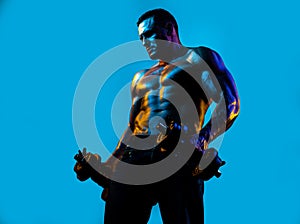 Muscular bodybuilder guy doing exercises with dumbbells isolated on blue neon. Fitness man. Handsome young muscular