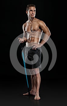 Muscular bodybuilder guy doing exercises with expander