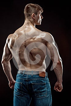 Muscular bodybuilder guy doing posing over black background