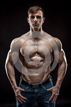 Muscular bodybuilder guy doing posing over black background