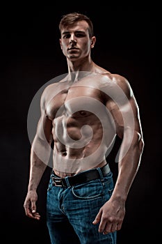 Muscular bodybuilder guy doing posing over black background