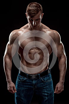 Muscular bodybuilder guy doing posing over black background