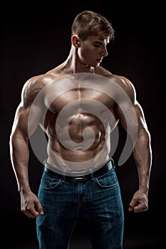 Muscular bodybuilder guy doing posing over black background