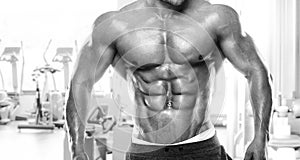 Muscular bodybuilder guy standing on gym