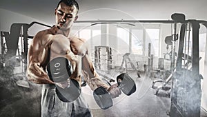 Muscular bodybuilder in the gym training with dumbbells