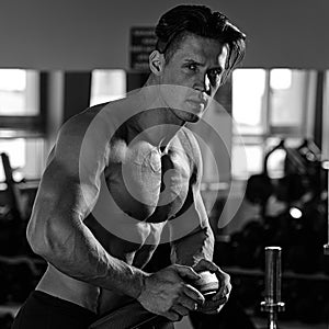 Muscular bodybuilder preparing to exercise in the gym.