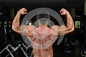 Muscular bodybuilder showing his back double biceps