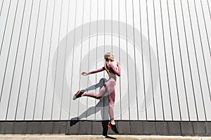Muscular build young woman jumping and running outdoor