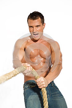 Muscular builder man pulling rope