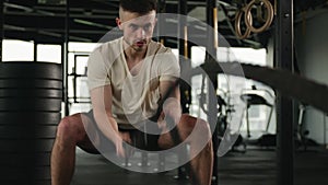 Muscular Caucasian man athlete bodybuilder fighter exercise battle ropes male sportsman training physical strength