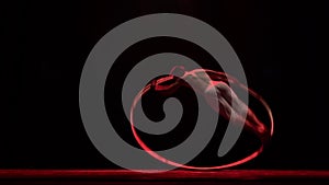 Muscular circus artist perform Cyr Wheel on a black background. Concept of willpower, motivation and passion