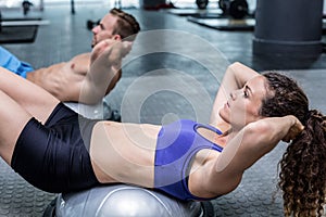 Muscular couple doing bosu ball exercises