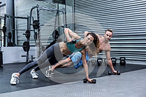 Muscular couple doing plank exercise together