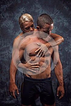 Muscular couple embracing