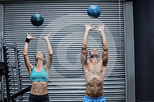 Muscular couple throwing ball in the air