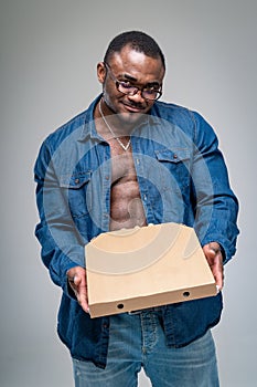 Muscular delivery pizza man. Young delivery courier holding pizza box.