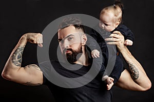 Muscular father holding his little baby