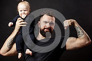 Muscular father holding his little baby photo