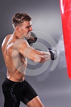 Muscular Fighter Practicing Some Kicks with Punching Bag.