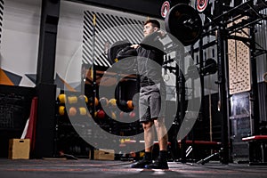 Muscular fit caucasian man lifting barbell in crossfit gym