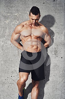 Muscular fit and healthy man standing on grey background