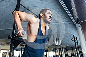 Muscular Fit Man Doing Pull Ups in the gym