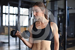 Muscular fit woman exercising building muscles at gym