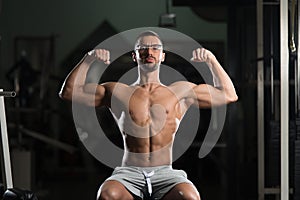 Muscular Geek Man Flexing Muscles In Gym