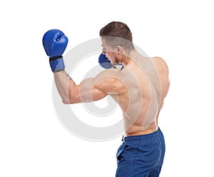 Muscular guy in boxing glove punches an uppercut on a white isolated background. Side view