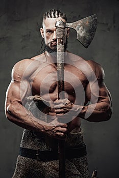 Muscular guy dressed like viking posing in dark background