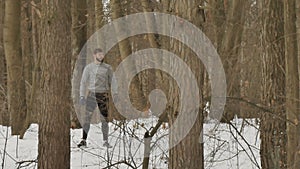 Muscular guy has a rest during running in winter forest