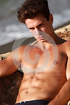 Muscular guy relaxing serious and thoughtful in the sea