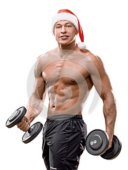 Muscular handsome sexy Santa Claus bodybuilder guy doing exercises with dumbbells over