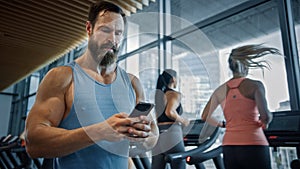 Muscular Heavyweight Champion Walks Through Gym, Uses Smartphone for Social Media and Conducting