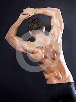 Muscular male back on black background