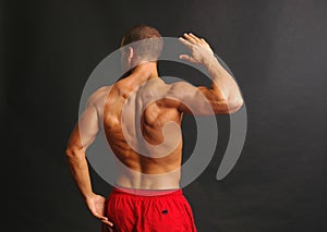 Muscular male back in red shorts