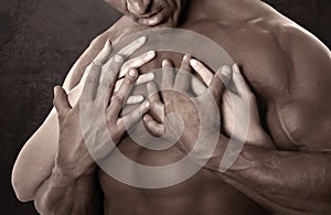 Muscular male body. Holding female hands