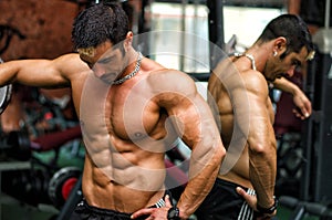 Muscular male bodybuilder resting in gym during workout