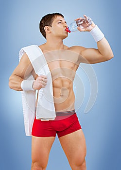 A muscular male drinking water from bottle