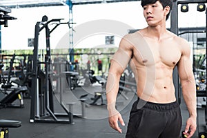 Muscular male having pain on shoulder in gym. young man injure