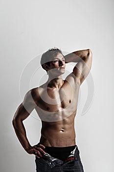 Muscular male model bodybuilder with unbuttoned jeans. Studio sh