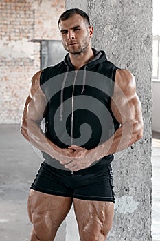 Muscular man with big quadriceps muscles in gym
