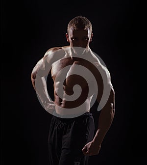 Muscular man on black background in studio