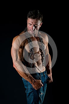 Muscular man with chain on sexy body. man with sexy bare torso in jeans. Athlete with sexy bare torso in jeans