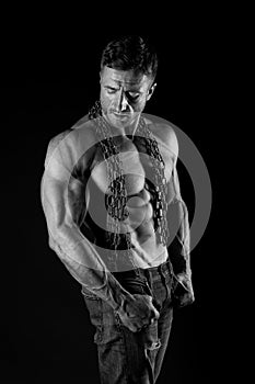 Muscular man with chain on sexy body. man with sexy bare torso in jeans. Athlete with sexy bare torso in jeans