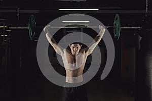 Muscular man at a crossfit gym lifting a barbell.