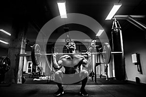 Muscular man at a crossfit gym lifting a barbell.