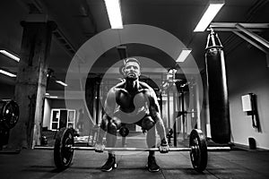 Muscular man at a crossfit gym lifting a barbell.