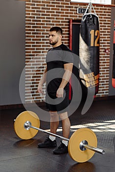 Muscular man at a crossfit gym prepare to lifting a barbell.