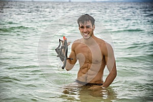 Muscular man with diving mask in hands